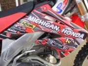 Another dirtbike wrapped with General Formulations MotoMark with various sponsor logos on it